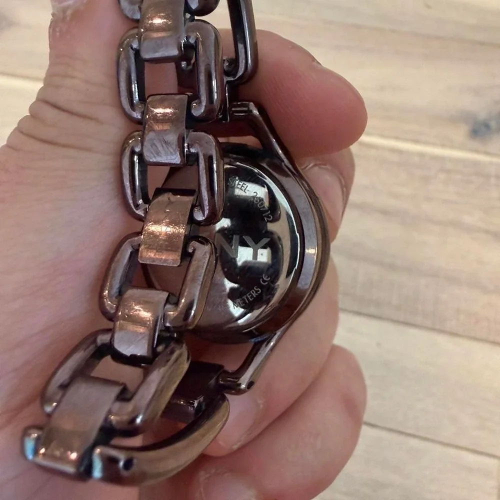 brown DKNY wristwatch featuring a distinct oval case and chain-link bracelet
